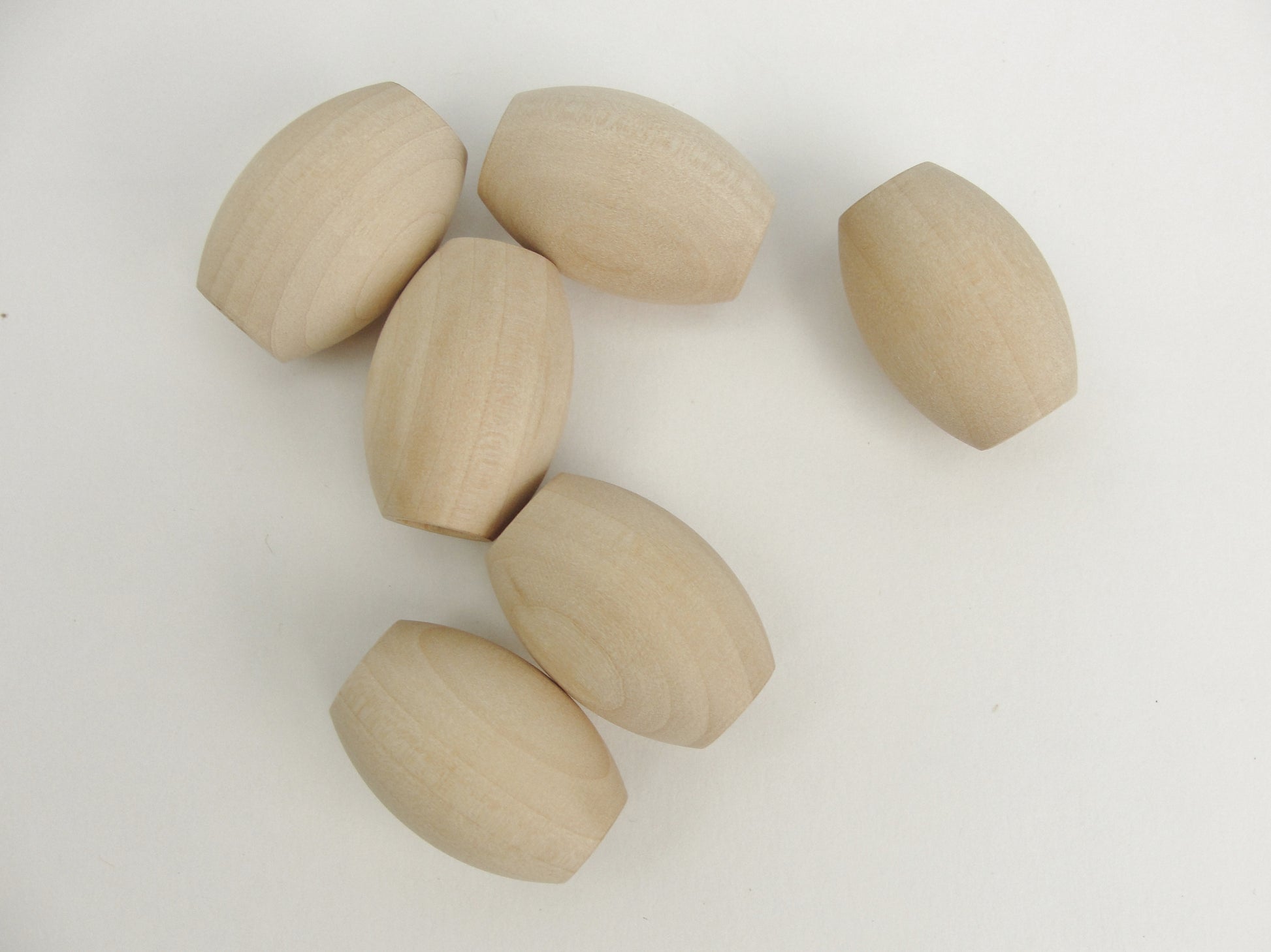 Wooden oval beads 1 1/4" x 7/8" with a 3/8" hole - Wood parts - Craft Supply House