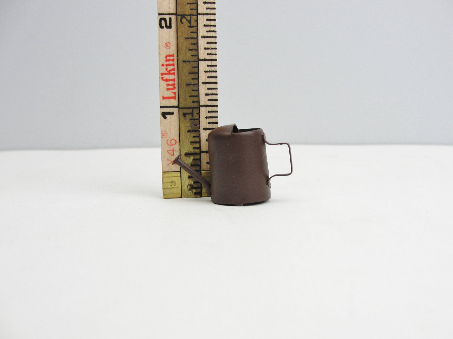 Miniature rust colored metal watering can